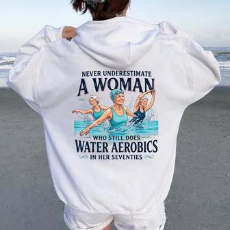 Never Underestimate A Woman Water Aerobics In Her Seventies Women Oversized Hoodie Back Print - Thegiftio UK